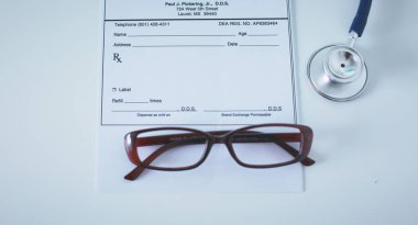 Doktorların çalışma alanı çalışma tablosu hastalar deşarj boş kağıt formu, tıbbi reçete, stetoskop üstünde okul sırası ile