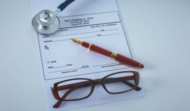 Doktorların çalışma alanı çalışma tablosu hastalar deşarj boş kağıt formu, tıbbi reçete, stetoskop üstünde okul sırası ile