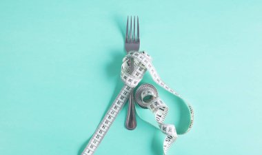 The fork is wrapped with a measuring tape on the table. Diet clipart