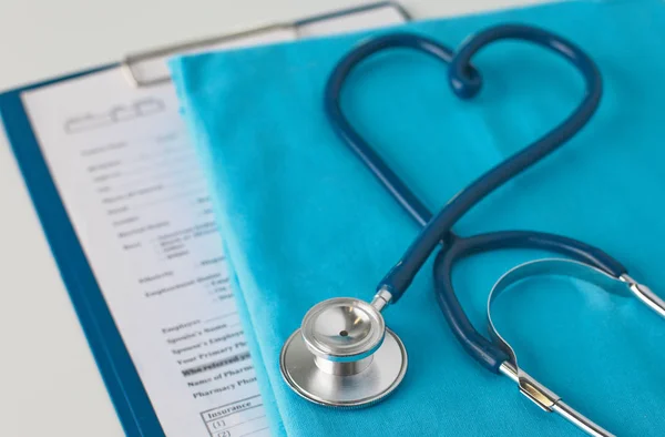 Estetoscopio en una mesa con uniforme médico —  Fotos de Stock