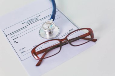 Doktorlar çalışma alanı çalışma tablosu ile hastaların taburcu boş kağıt formu, tıbbi reçete, stetoskop üstünde okul sırası, seçici odak