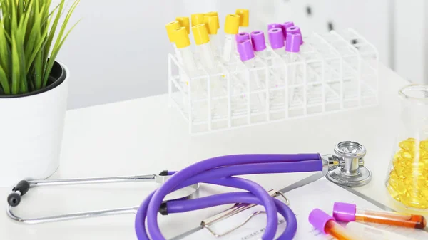 Close-up van de balie van een kantoor van de artsen met een stethoscoop op de voorgrond en een fles met pillen op de achtergrond, selectieve aandacht — Stockfoto
