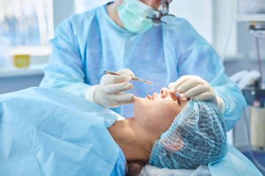 Birkaç doktor hasta operasyon masası üzerinde onların çalışma sırasında çevreleyen. Takım cerrahlar ameliyathane içinde işte