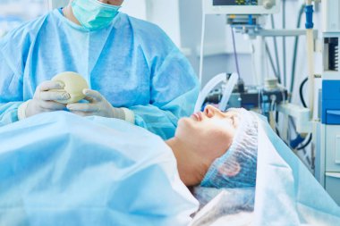 Birkaç doktor hasta operasyon masası üzerinde onların çalışma sırasında çevreleyen. Takım cerrahlar ameliyathane içinde işte