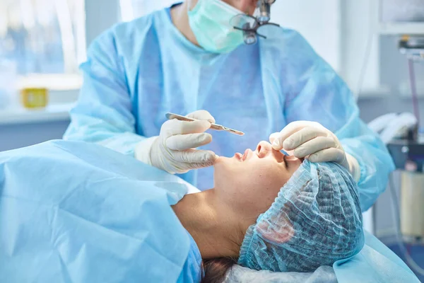 Several doctors surrounding patient on operation table during their work. Team surgeons at work in operating room — Stock Photo, Image