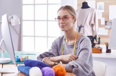 Masasında dikiş makinesi olan bir fabrikada genç ve güzel bir kız.