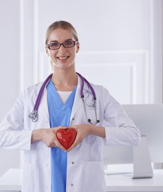 Kalbi tutan steteskoplu bir doktor, beyaz arka planda izole edilmiş.