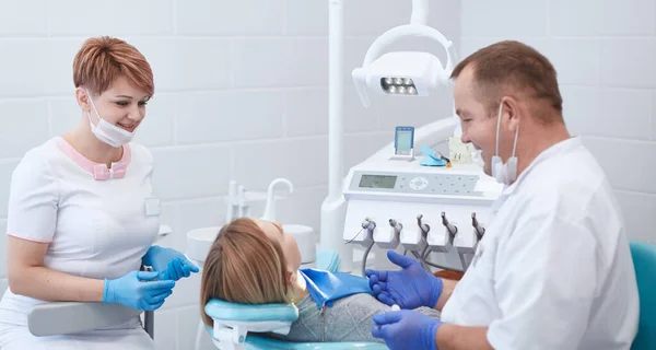 Врач-дантист лечит зубы красивой молодой пациентки. Девушка на ресепшене у дантиста. Доктор дантист лечит зуб — стоковое фото