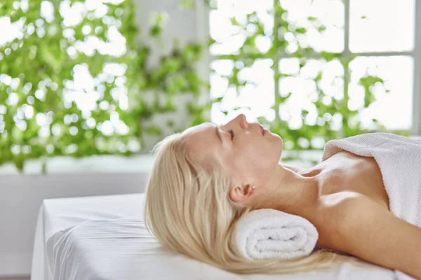Mulher bonita com olhos fechados recebendo uma massagem no salão de spa — Fotografia de Stock