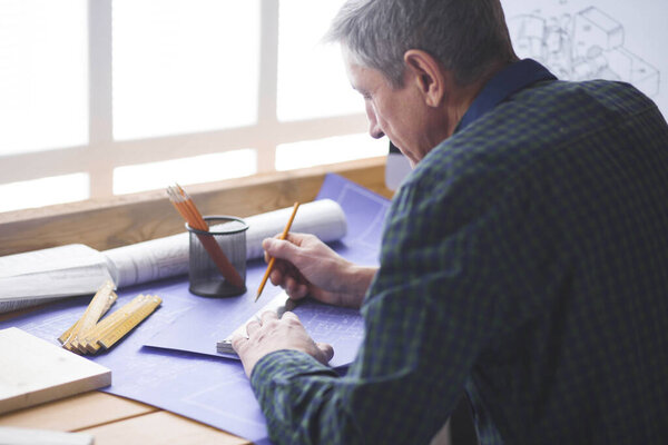 Плотник-инженер, работающий над проектом ноутбука и эскиза
