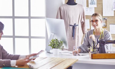 Güzel terzi müşterisine yeni bir tasarım gösteriyor