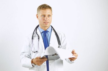 Steteskoplu beyaz önlüklü, kendine güvenen genç bir doktor.