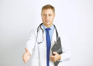 Steteskopla elini uzatan beyaz önlüklü genç doktor.