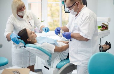 Doktor dişçi genç ve güzel bir kızın dişlerini tedavi ediyor. Dişçinin resepsiyonundaki kız. Doktor dişçi dişleri tedavi eder.