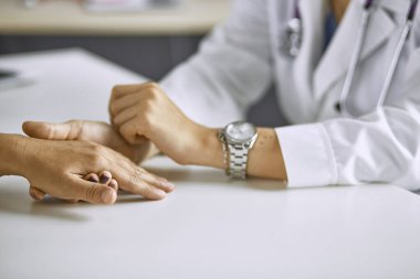 Kadın doktor hastayı sakinleştirir ve elini tutar