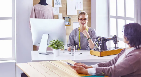 Hübsche Schneiderin zeigt ihrem Kunden ein neues Design — Stockfoto