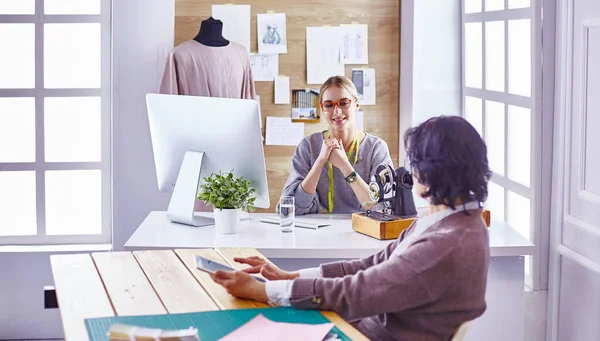 Hübsche Schneiderin zeigt ihrem Kunden ein neues Design — Stockfoto