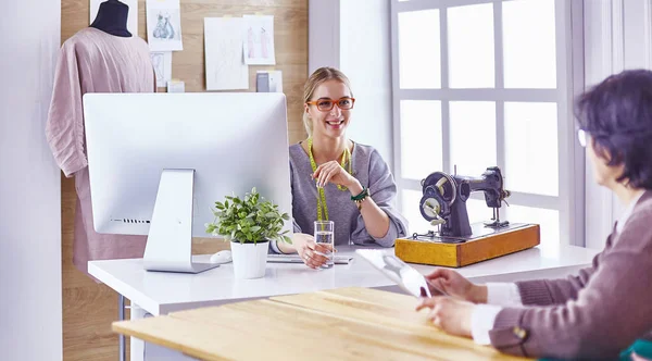 Hübsche Schneiderin zeigt ihrem Kunden ein neues Design — Stockfoto