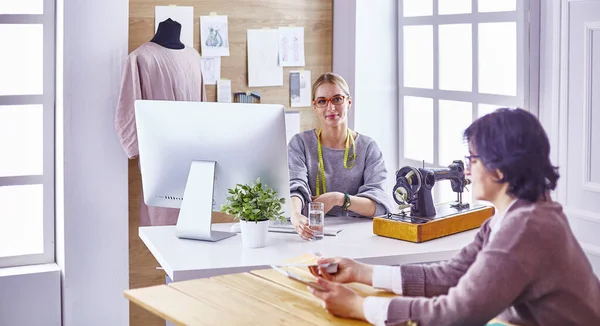 Hübsche Schneiderin zeigt ihrem Kunden ein neues Design — Stockfoto