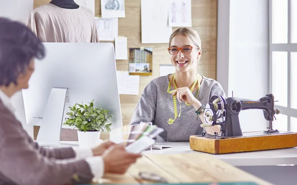 Bonita modista mostrando un nuevo diseño a su cliente — Foto de Stock