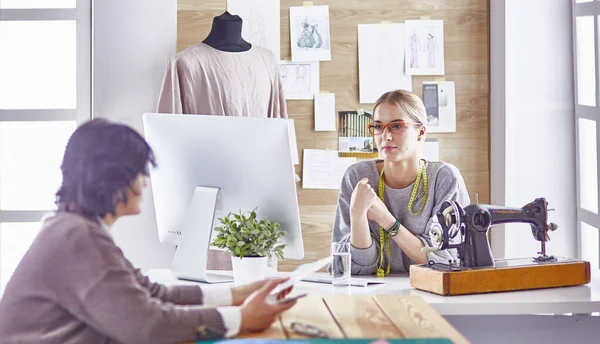 Bonita modista mostrando un nuevo diseño a su cliente — Foto de Stock