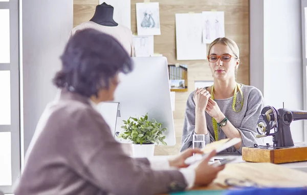 Bonita modista mostrando un nuevo diseño a su cliente — Foto de Stock