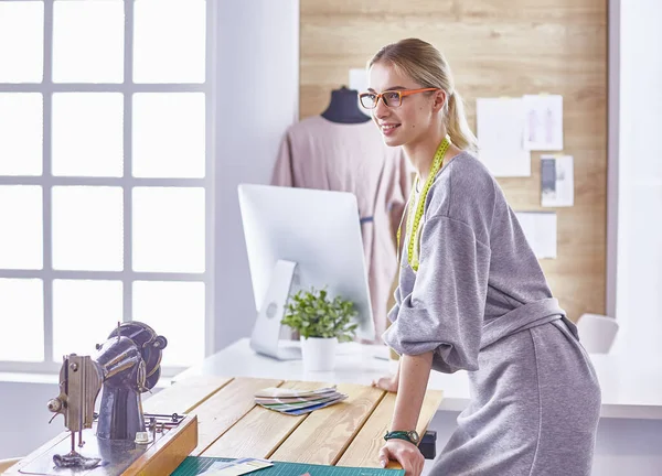 Attraktive Modedesignerin, die im Büro arbeitet, am Schreibtisch lehnt, zeichnet — Stockfoto