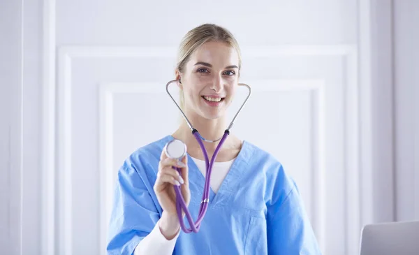Portret szczęśliwego uśmiechniętego młodego lekarza w zestawie słuchawkowym w biurze — Zdjęcie stockowe