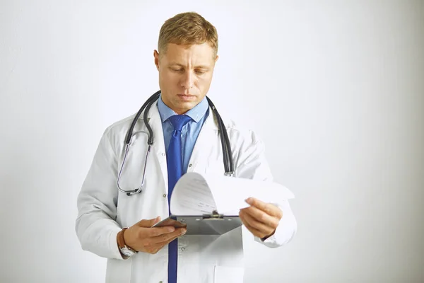 Молодой уверенный доктор в белом халате со стетоскопом — стоковое фото