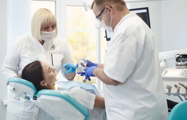 Doctor dentist treats teeth of a beautiful young girl patient. The girl on reception at the dentist. Doctor dentist treats tooth — Stock Photo, Image