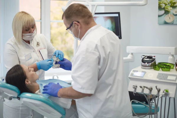 Doctor dentist treats teeth of a beautiful young girl patient. The girl on reception at the dentist. Doctor dentist treats tooth — Stock Photo, Image