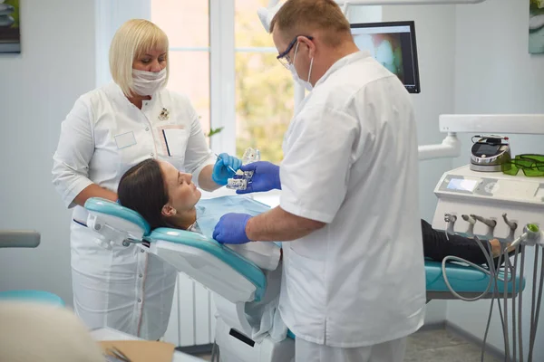 Doctor dentist treats teeth of a beautiful young girl patient. The girl on reception at the dentist. Doctor dentist treats tooth