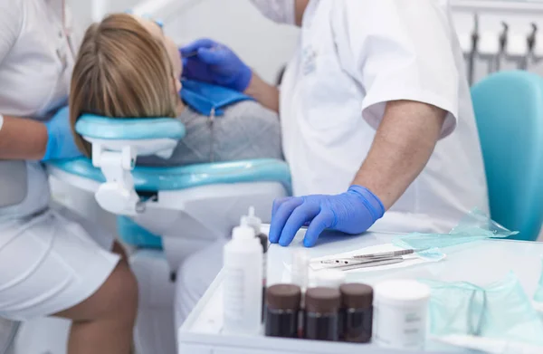 Médico dentista trata os dentes de uma bela jovem paciente. A rapariga na recepção do dentista. Médico dentista trata dente — Fotografia de Stock