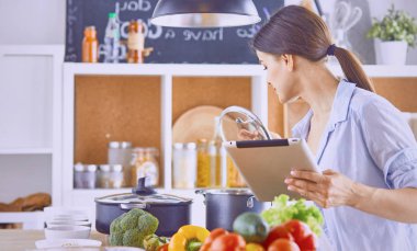 Bir genç görüntü güzel kız mutfakta ayakta ve coo