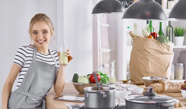 The girl at the table in the kitchen with a glass of orange jui — Stock Photo, Image