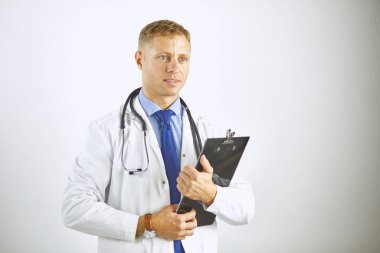 Steteskoplu beyaz önlüklü, kendine güvenen genç bir doktor.