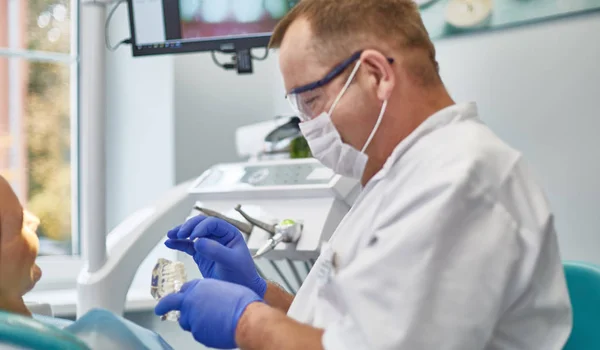 Doctor dentist treats teeth of a beautiful young girl patient. — Stock Photo, Image