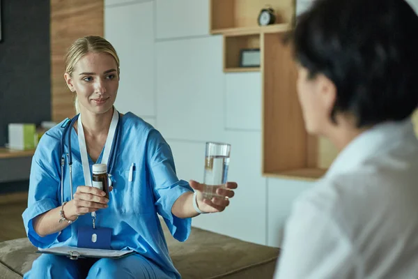 Schöne lächelnde Frau der Arzt in einer Flasche Pille bietet t — Stockfoto