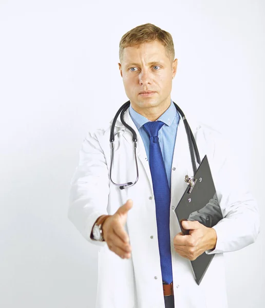 Νεαρός γιατρός με λευκό παλτό και στηθοσκόπιο σας χαιρετά κρατώντας σας — Φωτογραφία Αρχείου