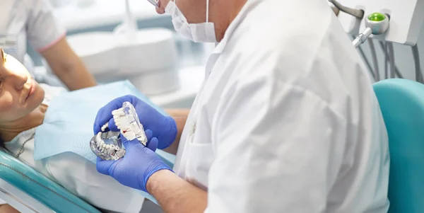 Doctor dentist treats teeth of a beautiful young girl patient. — Stockfoto