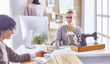 Güzel terzi müşterisine yeni bir tasarım gösteriyor