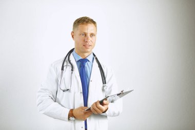 Steteskoplu beyaz önlüklü, kendine güvenen genç bir doktor.