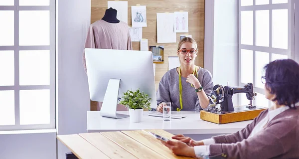 Hübsche Schneiderin zeigt ihrem Kunden ein neues Design — Stockfoto