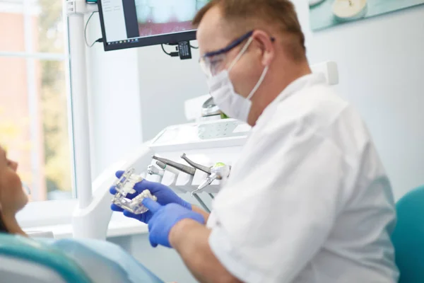 Doctor dentist treats teeth of a beautiful young girl patient. — Stock Photo, Image