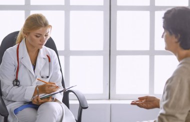 Genç bayan doktor hastasını ofise alıyor.