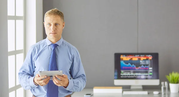 Portrait of smiling happy young entrepreneur standing at his of — ストック写真