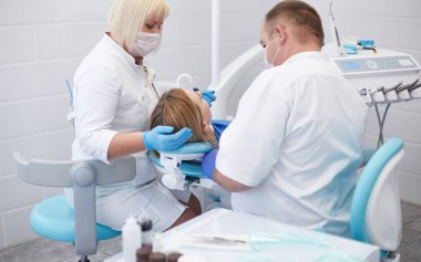 Doctor dentist treats teeth of a beautiful young girl patient.