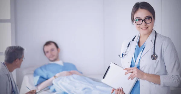 Médico verificando batimento cardíaco do paciente na cama com estetoscópio — Fotografia de Stock