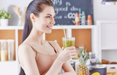 genç bir kız bir kokteyl bir mutfak içecekler.