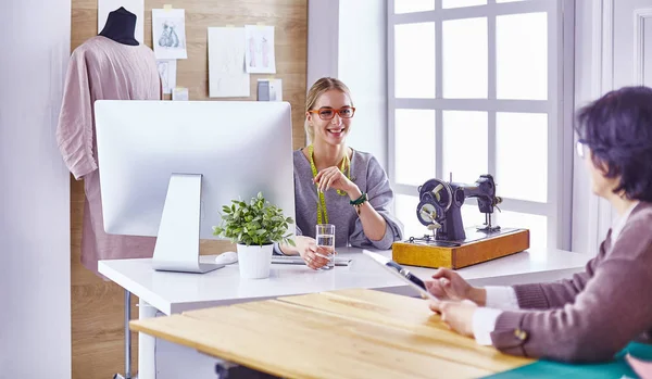 Hübsche Schneiderin zeigt ihrem Kunden ein neues Design — Stockfoto